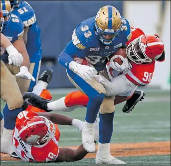  ?? THE CANADIAN PRESS ?? Blue Bombers’ Andrew Harris gets wrapped up by Lions’ defensive lineman Mic’hael Brooks during Saturday’s game in Winnipeg. The Bombers won, but their offence was held without a touchdown and has, in fact, been struggling to put up points for a few...