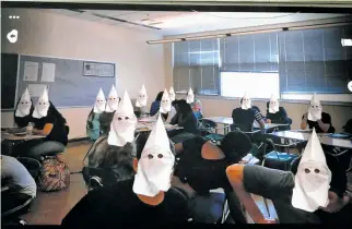  ?? FACEBOOK PHOTO ?? This photo, taken in a classroom of Volcano Vista High School in Albuquerqu­e, shows two black students surrounded by classmates with Ku Klux Klan hoods superimpos­ed over their faces. The students responsibl­e for posting the photo on Snapchat were...