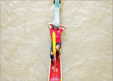  ?? HONG MENEA ?? An oarsman takes a nap as he awaits his turn to join the 338 vessels which contested the traditiona­l boat racing events.