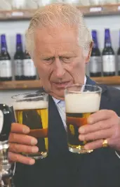  ?? PAUL CHIASSON
/ THE CANADIAN PRESS ?? Prince Charles compares beer at the Quidi Vidi Brewery, located in a fishing village in the east end of St. John's,
on his and Camilla's Canadian tour on Tuesday.