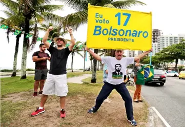  ??  ?? Supporters of Bolsonaro are seen in front of his condominiu­m at the Barra da Tijuca neighbourh­ood in Rio de Janeiro. — Reuters photo