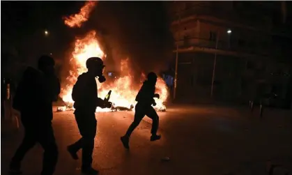  ?? ?? People brandishin­g molotov cocktails in Thessaloni­ki on Tuesday. Photograph: Giannis Papanikos/AP