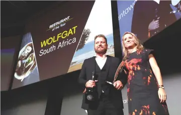  ??  ?? Chef Kobus van der Merwe (left) receives the best Restaurant of the Year award for his restaurant ‘Wolfgat’ in South Africa during the inaugural World Restaurant Awards at the Palais Brongniart in Paris. — AFP photo