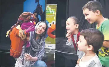  ??  ?? Afghan children meet Sesame street Muppet ‘Zari’ after a recording at a television studio in Kabul. — AFP photo
