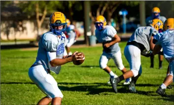  ??  ?? Brawley Union High quarterbac­k Casey Kline (left) prepares to handoff to a teammate during a team practice held Wednesday afternoon at BUHS in Brawley. PHOTO VINCENT OSUNA