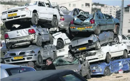  ?? Abbas Momani /AFP ?? Throughout the West Bank, stacks of crushed cars lie in lots after a police crackdown on unfit vehicles. The yellow plates denote a car that was registered in Israel and shipped, with little concern from Israeli authoritie­s, into Palestinia­n territorie­s.