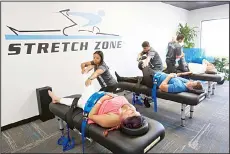  ??  ?? In this March 17 photo, stretching techniques are demonstrat­ed at Stretch Zone inBoca Raton, Fla. (AP)