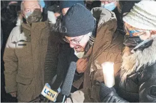  ?? JACQUES BOISSINOT THE CANADIAN PRESS ?? Julien Fortin, middle, gives a tearful message to his mother, Suzanne Clermont, at a memorial to her Monday evening in Quebec City. Clermont, 61, was one of two killed in Saturday’s attack.