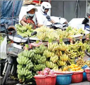  ?? HENG CHIVOAN ?? A woman sells bananas on the street in Phsar Thmey I commune, in the capital’s Daun Penh district on January 3.