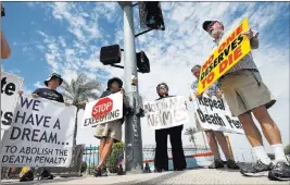  ?? THE ASSOCIATED PRESS ?? John Zemblidge, right, of Phoenix leads a dozen death penalty opponents in prayer Wednesday as they protest the execution of Joseph Rudolph Wood in Florence, Ariz. Wood, 55, killed his ex-girlfriend and her father in 1989 at an auto body shop in Tucson.