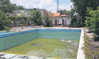  ??  ?? ABANDONO. El antiguo inmueble del Casino Sampedrano no solo es refugio de delincuent­es, sino también criadero de zancudos por la maleza y el agua acumulada en la piscina.