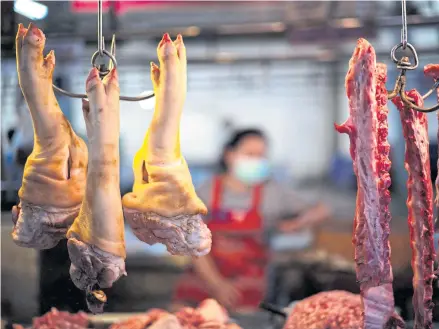  ?? REUTERS ?? A vendor sells pork at a market stall in the capital. Due to massive deaths of swine, may pig farmers have been forced out of business.