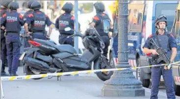  ?? AFP ?? Armed policemen stand guard in a cordoned off area on Barcelona's famous Las Ramblas avenue on Thursday.