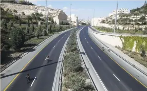  ?? (Reuters/Ammar Awad) ?? CHILDREN RIDE bicycles on an empty street in Jerusalem during Yom Kippur last year.