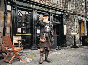  ?? PHOTO: JEFF J MITCHELL/GETTY IMAGES ?? Glass half empty: A man finishes his drink outside an aptly named pub in Edinburgh yesterday ahead of the introducti­on of tougher restrictio­ns in Scotland.