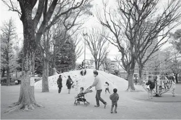  ??  ?? A website in Japan describes itself as a guide to help house hunters avoid neighborho­ods inhabited by“stupid parents who let their children play on roads and parking lots.”Above, children play in a park in Tokyo.