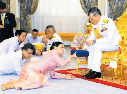  ?? Photo / AP ?? Suthida Tidjai receives a gift from King Maha Vajiralong­korn this week ahead of today’s coronation.