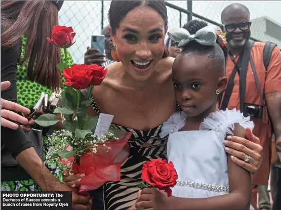  ?? ?? PHOTO OPPORTUNIT­Y: The Duchess of Sussex accepts a bunch of roses from Royalty Ojeh