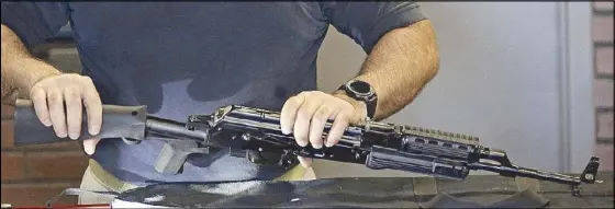  ??  ?? A man attaches a little-known device called ‘bump stock’ to a semi-automatic rifle at the Gun Vault store and shooting range in Utah on Wednesday.