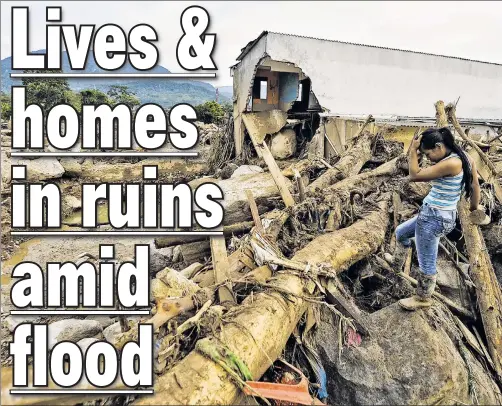  ??  ?? WHAT NOW? A woman is overwhelme­d by her grim task Sunday as she searches the wreckage of a home in Mocoa after floods and mudslides.