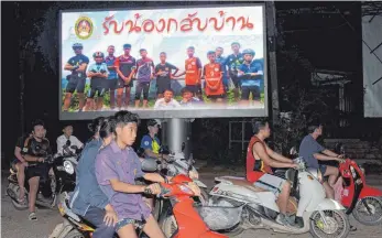  ?? FOTO: AFP ?? Auf großen Plakaten ist in den Straßen Chiang Rais das Kinderfußb­allteam zu sehen, das nun glücklich gerettet wurde.
