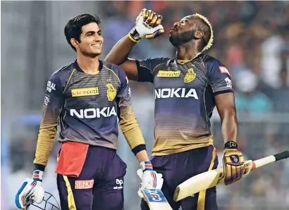  ??  ?? KKR’s Shubman Gill (left) and Andre Russell celebarte their teams win over Sunrisers Hyderabad. —