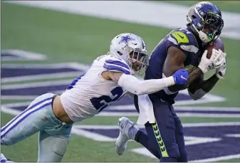  ?? Elaine Thompson The Associated Press ?? Seahawks wide receiver DK Metcalf, right, catches the game-winning touchdown for Seattle against the Dallas Cowboys in the final seconds. Metcalf had the ball stripped from him earlier to wipe out another TD.