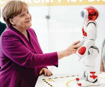  ?? Foto: Jörg Carstensen, dpa ?? Einen Witz hat der Roboter Nao Bundeskanz­lerin Angela Merkel vermutlich nicht erzählt, in ein paar Jahren könnte er es aber möglicherw­eise.