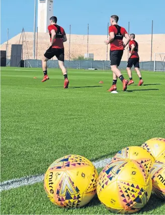  ??  ?? HOT TO TROT: Defender Scott McKenna leads the training run at Jebel Ali Resort as