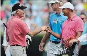  ?? CURTIS COMPTON TNS ?? Tiger Woods gets a fist bump from Fred Couples on the practice range at Augusta National Monday.