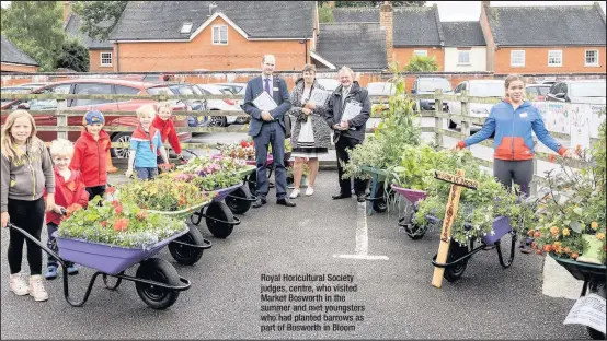  ??  ?? Royal Horicultur­al Society judges, centre, who visited Market Bosworth in the summer and met youngsters who had planted barrows as part of Bosworth in Bloom