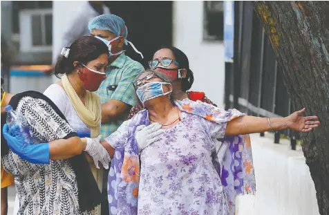  ?? ADNAN ABIDI/REUTERS ?? A woman mourns Friday after seeing the body of her son who died of COVID-19 outside a mortuary in the village of Banail in the Indian state of Uttar Pradesh. The pandemic has devastated India's rural areas.