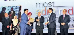  ??  ?? Dr. Parakrama Dissanayak­e receiving the award for the Most Admired Companies Sri Lanka 2019