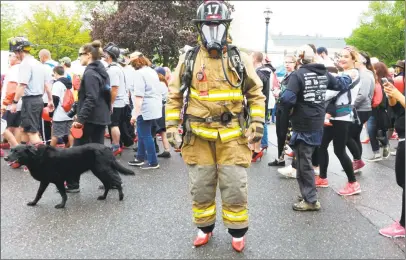  ?? N.F. Ambery / Hearst Connecticu­t Media ?? Steven Torali, 20, a firefighte­r with the Torringfor­d Volunteer Fire Department, makes an unlikely sight Sunday morning in his fire gear, complete with oxygen mask and tank, bedecked in red high heels.