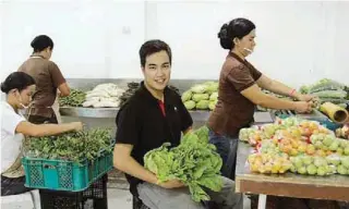  ??  ?? Jonathan and lady workers prepare vegetables for the market.