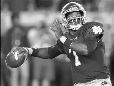  ?? Carlos Osorio The Associated Press ?? Notre Dame quarterbac­k Brandon Wimbush looks to throw deep during the first half of the 13th-ranked Fighting Irish’s 49-14 victory over No. 11 Southern California on Saturday in South Bend, Ind. Wimbush passed for two touchdowns and ran for two more.