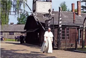  ?? ASSOCIATED PRESS PHOTOS ?? Pope Francis walks through the gate of the former Nazi German death camp of Auschwitz in Oswiecim, Poland, on Friday.