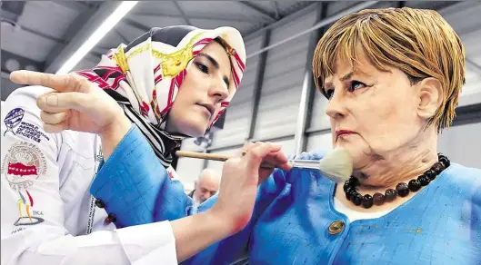  ?? DPA-BILD: MARTIN SCHUTT ?? Patissiere Tuba Geckil aus der Türkei stellte bei der Internatio­nalen Kocholympi­ade eine Bundeskanz­lerin Merkel her – komplett aus Zuckerpast­e. 2000 Köche und Patissiers aus 59 Ländern traten in Erfurt an.