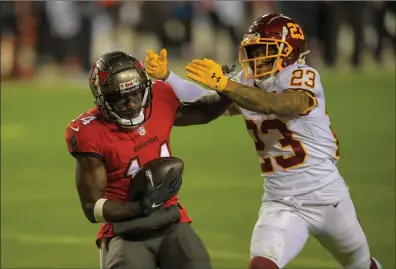  ?? Washington Post photo ?? Tampa Bay receiver Chris Godwin (14, above) caught a 27-yard touchdown pass from Tom Brady in the second quarter of the No. 5 Buccaneers 31-23 victory over No. 4 Washington in the Wild Card round of the NFC playoffs Saturday night.