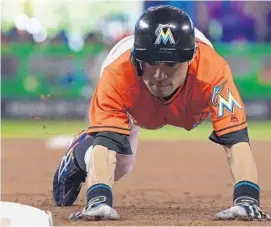  ?? MIKE EHRMANN/GETTY IMAGES ?? Ichiro Suzuki of the Miami Marlins dives back to first during the game against theWashing­ton Nationals at Marlins Park on Sunday.