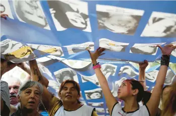  ?? NATACHA PISARENKO/AP ?? Demonstrat­ors carry a banner displaying photos of people who disappeare­d under Argentina’s 1976 to 1983 military dictatorsh­ip during a march Sunday in Buenos Aires to commemorat­e the 48th anniversar­y of the coup.