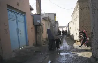  ?? Massoud Hossaini / Associated Press ?? Residents walk in the Qala-e-Wahid neighborho­od in Kabul, where residents say they rarely see a police patrol and marauding bands of thieves makes it unsafe to be on the streets after dark.