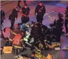 ?? JAMES ANDERSON VIA AP ?? Emergency workers tend to an injured person after a driver sped through a protest-related closure on the Interstate 5 freeway in Seattle on July 4. Dawit Kelete, 27, was charged with vehicular assault.