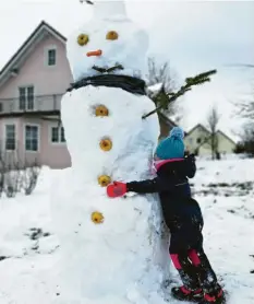  ??  ?? Das ist Ellena mit ihrem großen Schneemann. Seine Augen und Knöpfe bestehen aus Äpfeln.