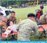  ?? ?? TAGUM, Philippine­s: This handout photo by the Philippine Army shows Philippine soldiers transferri­ng a landslide survivor from a helicopter to an ambulance. — AFP