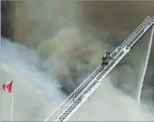  ?? CP PHOTO ?? Firefighte­rs battle a six-alarm fire on Yonge St. south of St.Clair Ave. in Toronto Tuesday. The blaze was finally declared extinguish­ed Wednesday morning.