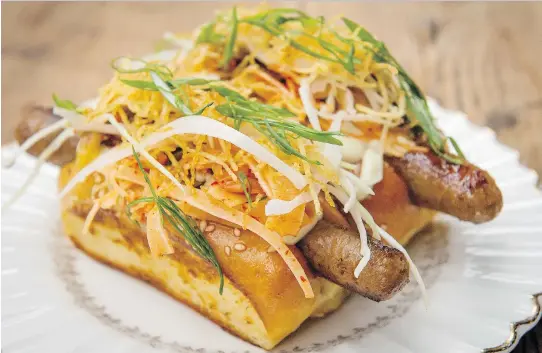  ?? PHOTOS: PETER MCCABE ?? A contender for greatness in the gourmet hotdog trend, Kampai Garden’s version is delicious, with a Gaspor pork sausage topped with kimchee and potato chips.