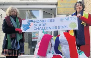  ??  ?? ●● Jill Partington, from Accrington’s North Lancs Training Group (right), hands over the scarves to Lucy Hardwick, manager of Maundy Relief