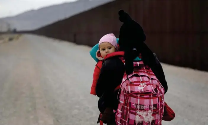  ??  ?? A Central American woman walks along the border in El Paso, Texas, on 1 February. Photograph: John Moore/Getty Images