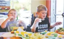  ??  ?? Owen Culberson, 4, and Noah Culberson, 7, of Ooltewah, Tenn., make sandwiches at the Dynamic Dietetics workshop at Subway in Cleveland, Tenn. Dietitians explained how to make better food choices to children and their parents.